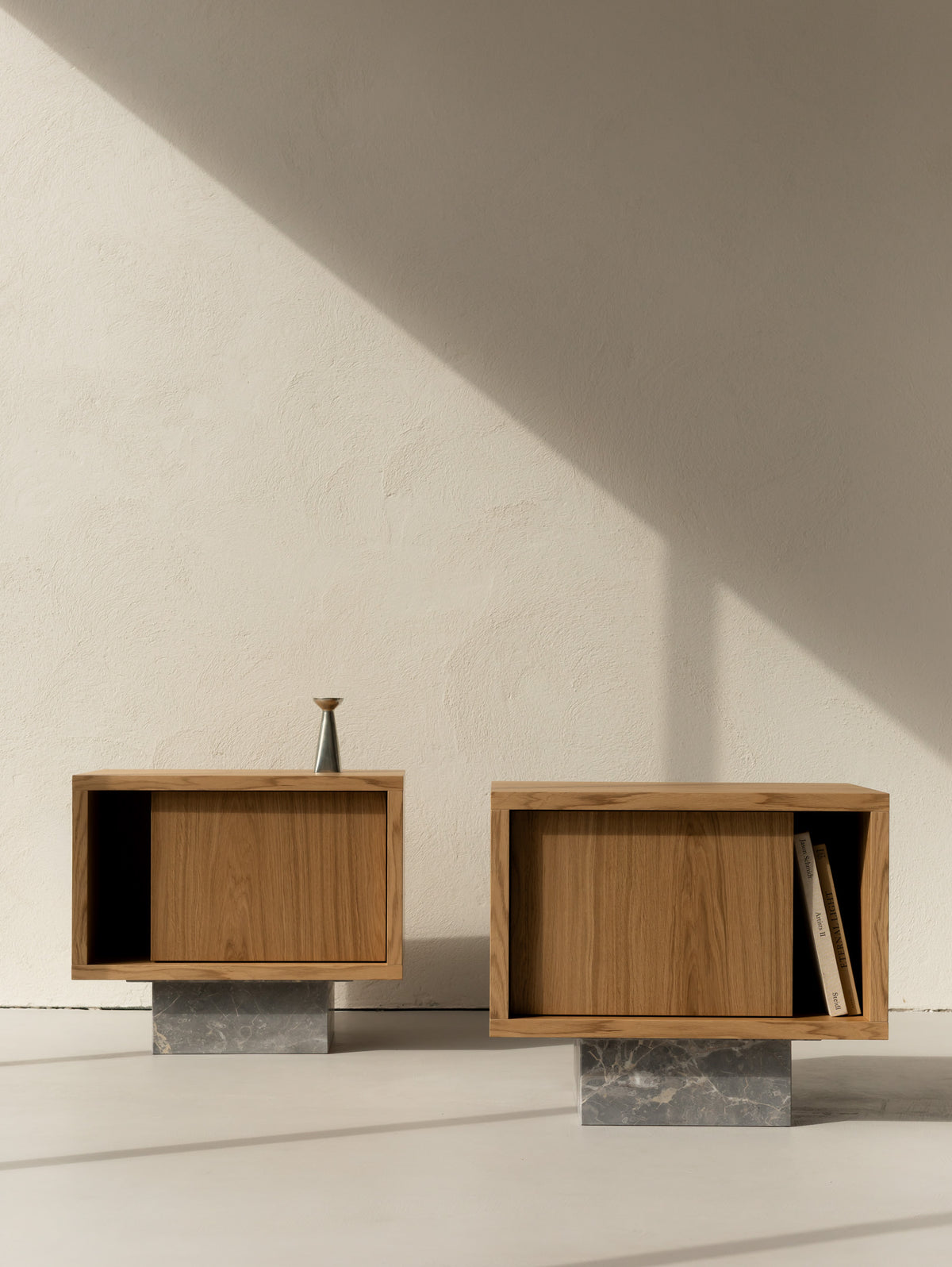 Pair of BLOCK Side Tables in natural oak on Fior di Bosco marble bases, bedside tables in left and right versions against a textured wall.