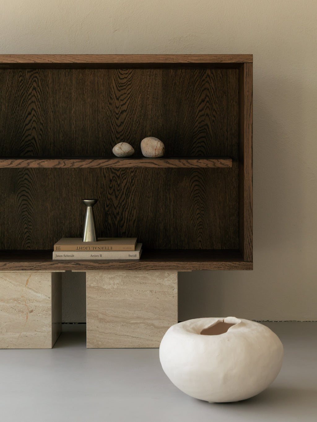 Un'common dark oak BLOCK Sideboard on Breccia marble block legs, styled with paired stones, a brass bud vase on stacked books, and an organic white ceramic bowl on the floor.