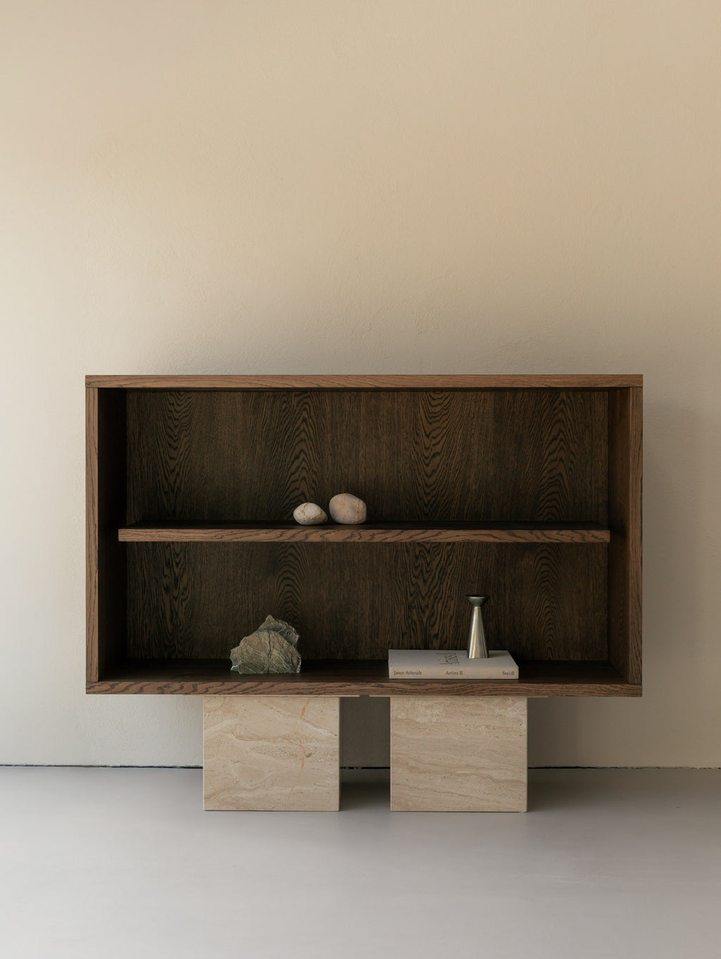 Front view of an Un'common BLOCK Sideboard oak shelving unit on breccia marble block legs, styled with natural stones, a brass vase, and art books.