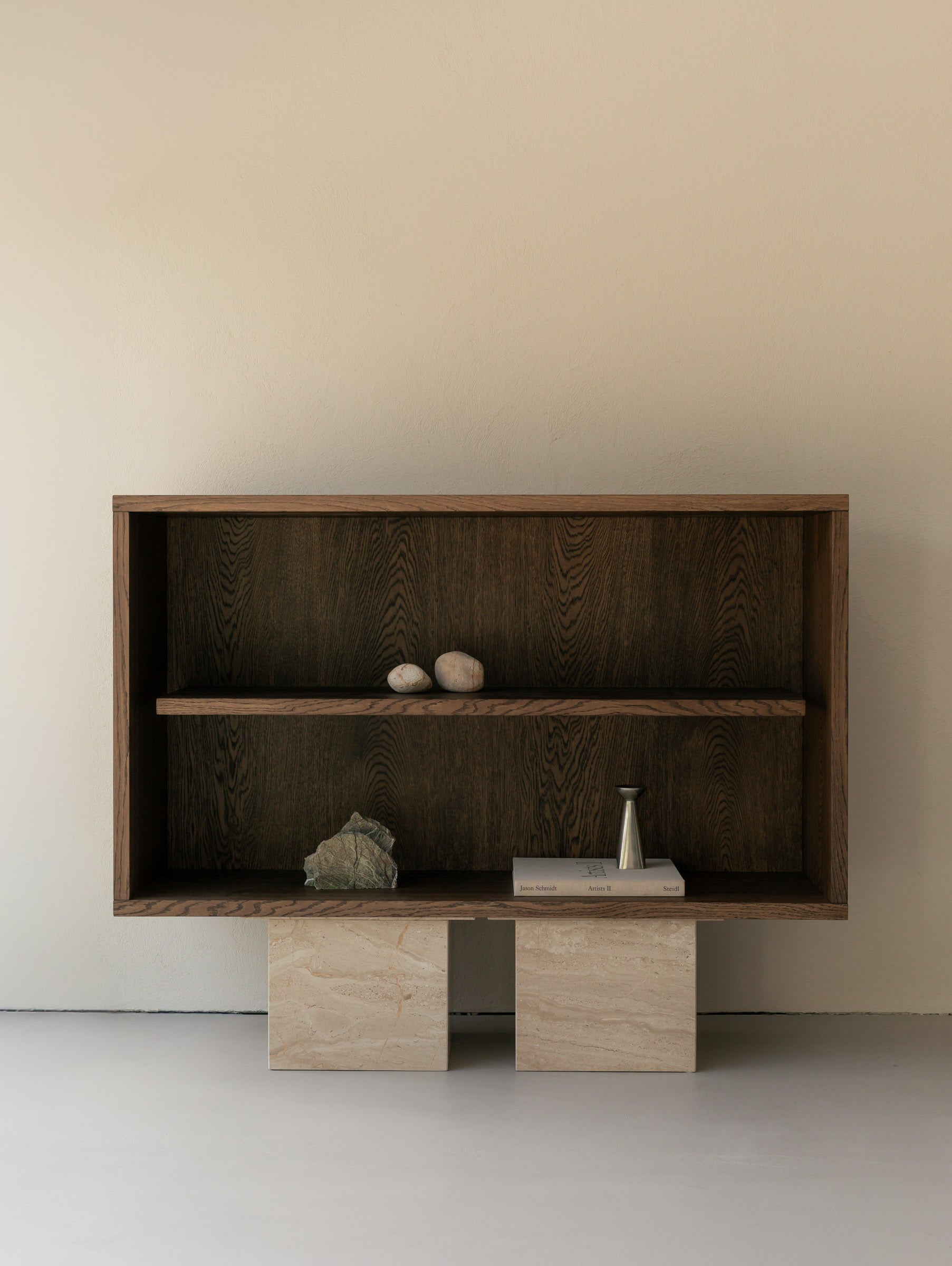 Front view of an Un'common BLOCK Sideboard oak shelving unit on breccia marble block legs, styled with natural stones, a brass vase, and art books.